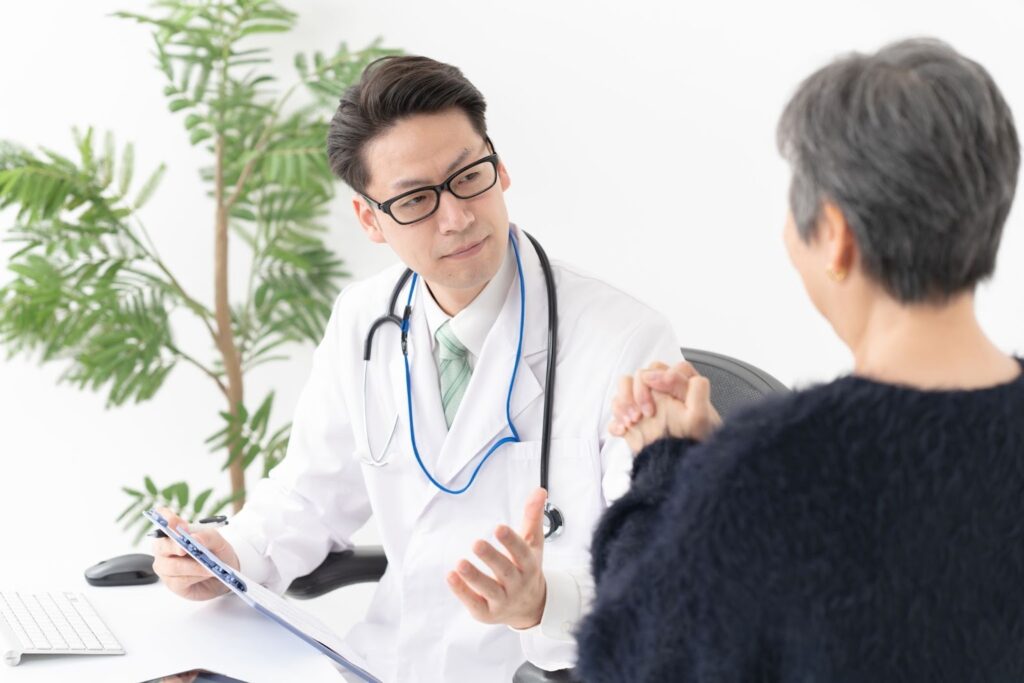 整形外科を受診し、交通事故に遭ったことについて医師に相談する人