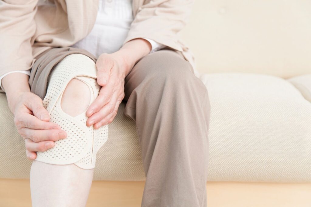 膝の痛みがつらく、膝にサポーターを巻いているシニアの足元