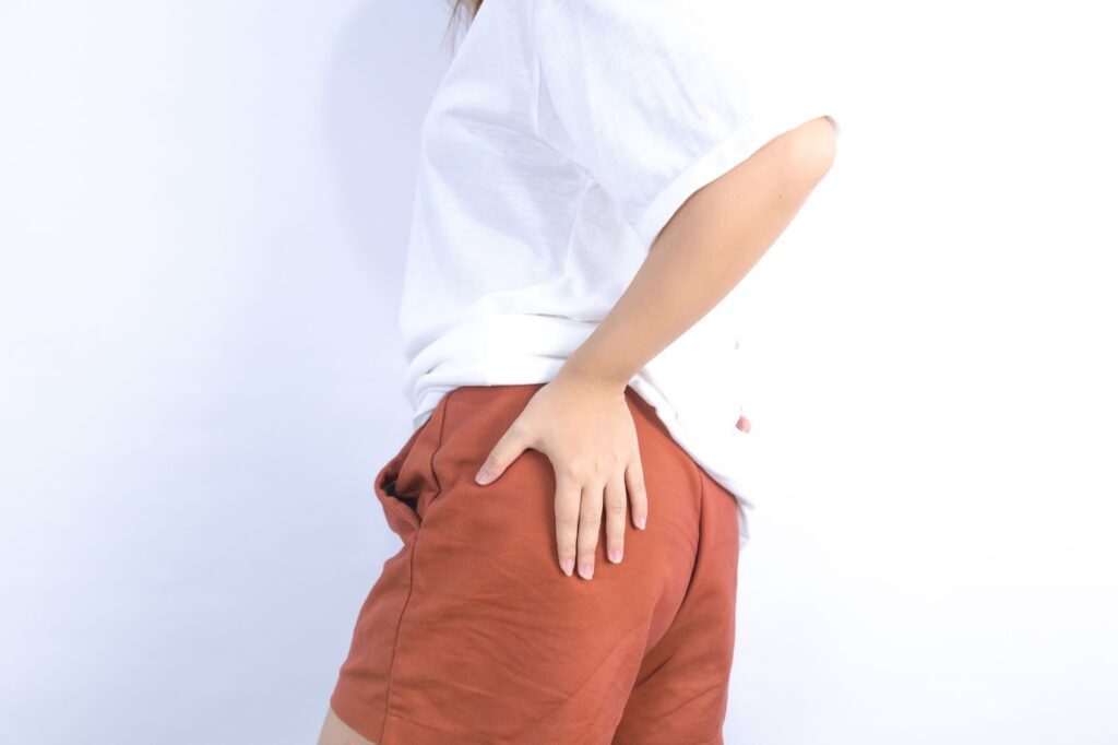 骨盤部分にてを当てている人