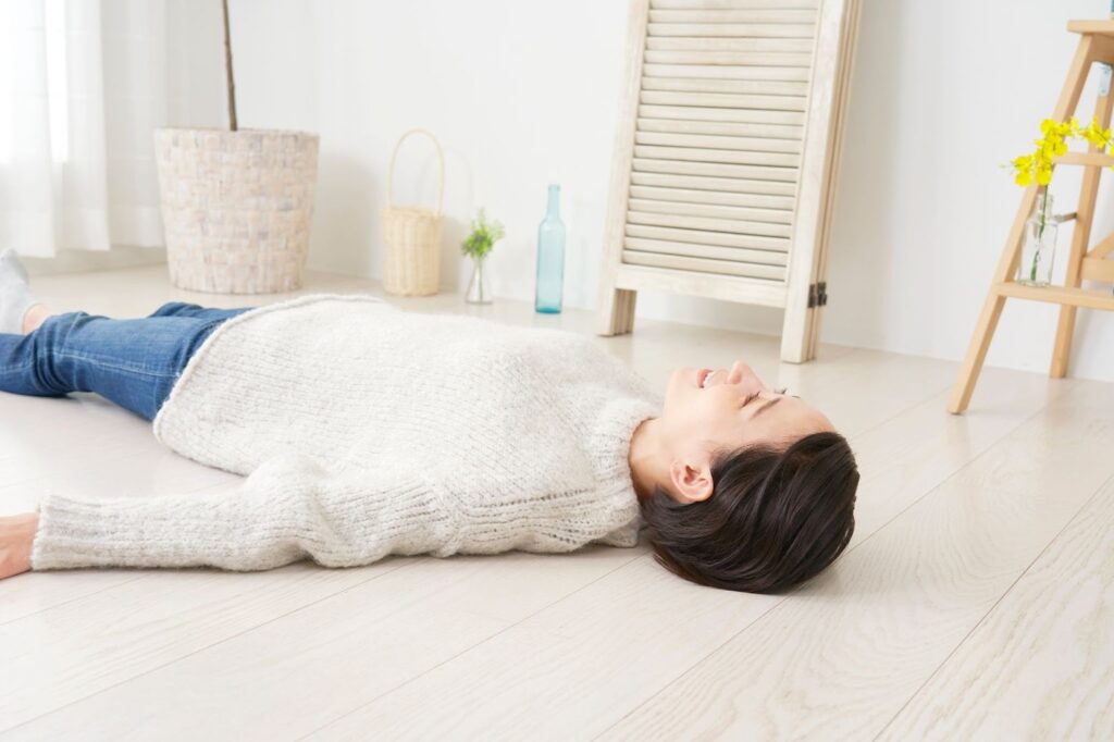 腰痛の原因になる反り腰のセルフチェックのため床に仰向けで寝ている女性
