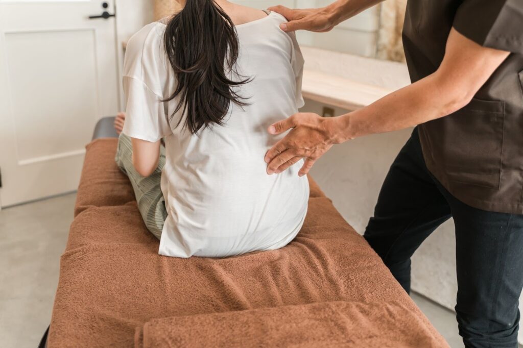 反り腰による腰痛がなかなか治らず接骨院で柔道整復師の施術を受ける女性
