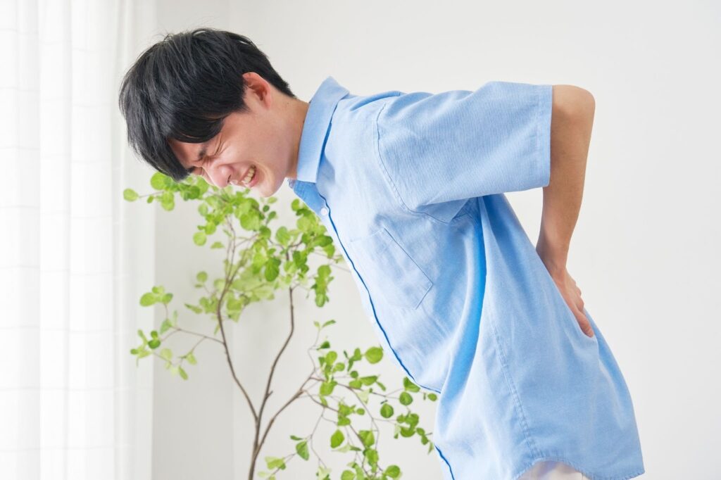 ぎっくり腰でつらそうに顔をしかめる男性