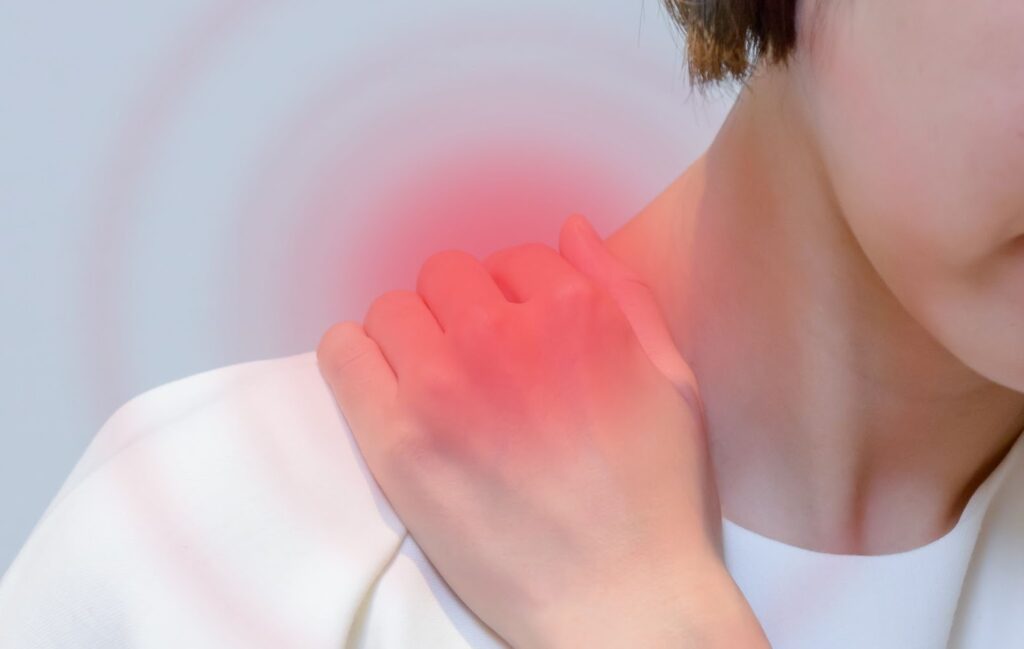 肩が痛みが手で肩を押さえている人