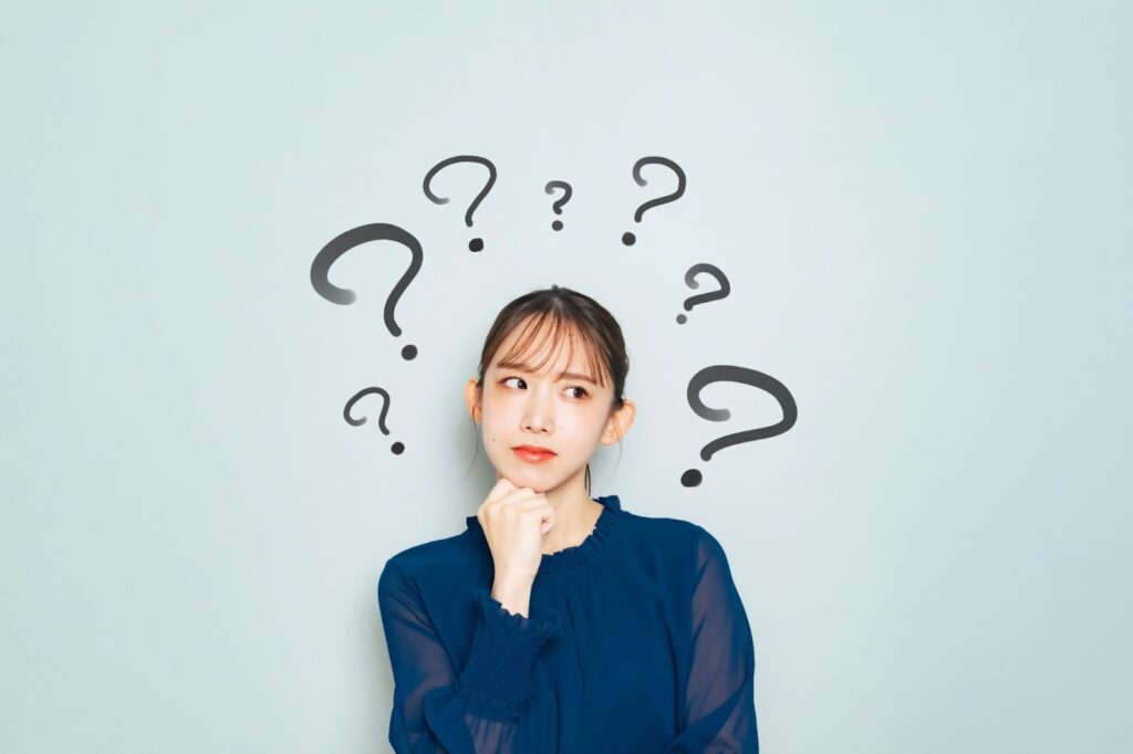 はてなマークに囲まれた女性