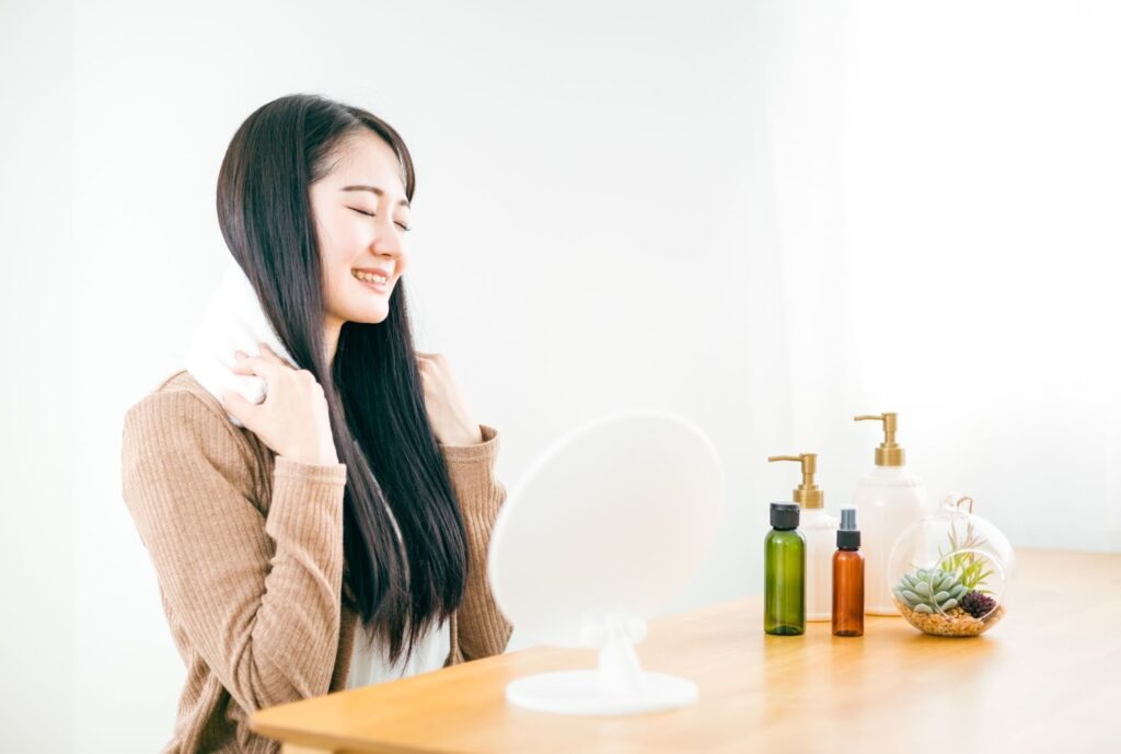 安全に肩のゴリゴリをほぐすセルフケアとして肩をホットタオルで温めている女性