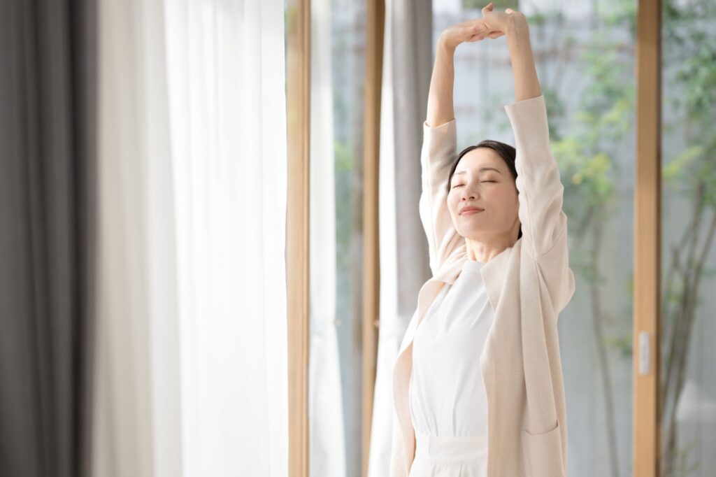 日常生活でできる肩こりケア方法としてストレッチを行う女性