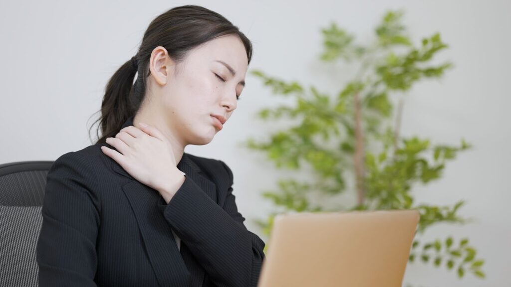 肩こりがひどすぎてつらそうな仕事中の女性