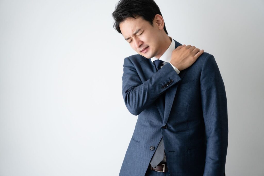 肩こりがひどすぎてつらそうなスーツの男性